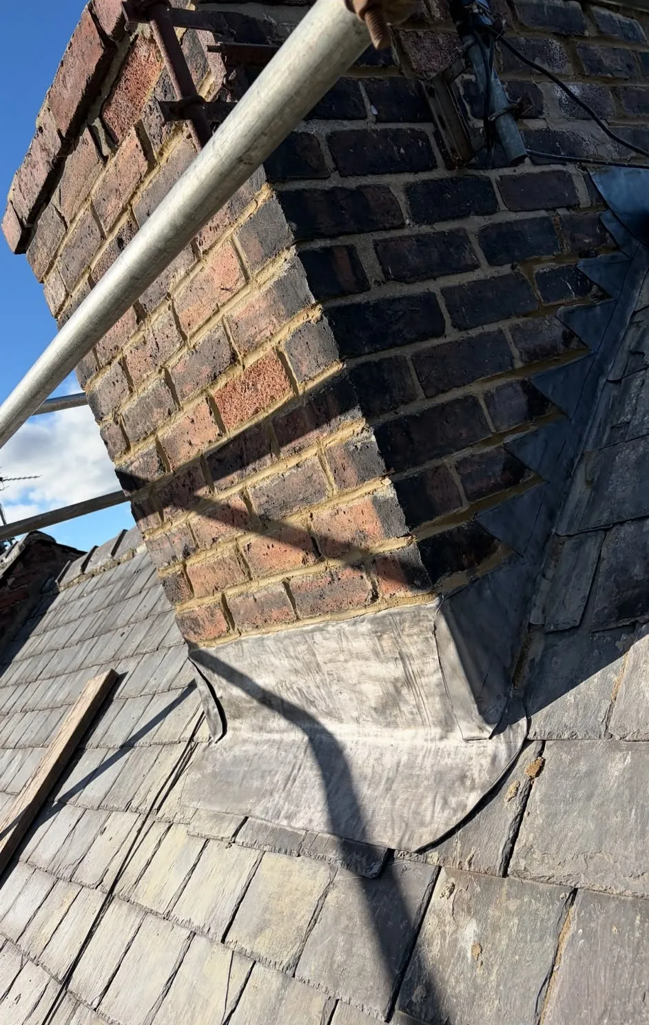 Chimney stack repointed with new stepped lead flashing on a slate roof
