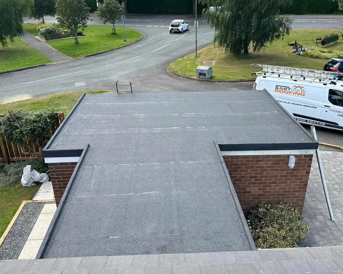 New felt flat roof on a brick garage with East View Roofing van alongside