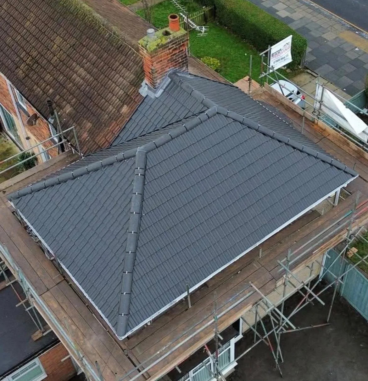 Aerial view of a new hipped pitched roof in grey concrete tiles with dry ridge, East View Roofing