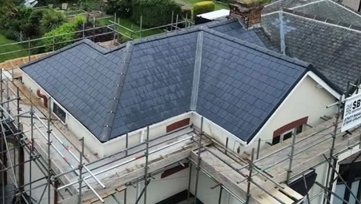 Aerial view of a new hipped slate roof with scaffolding