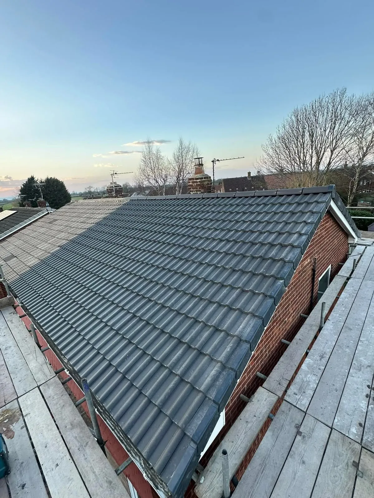 New pitched roof in grey interlocking tiles with dry verge on a bungalow