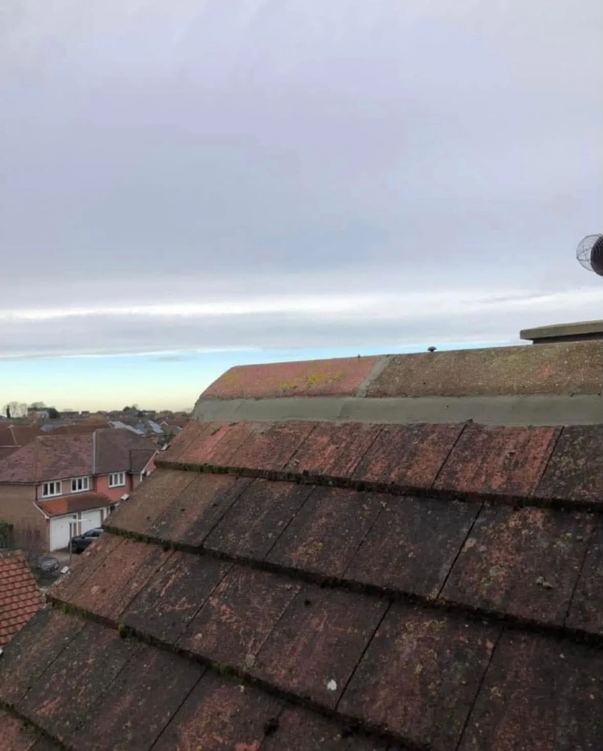 Roof ridge tiles repointed with fresh mortar on a red tiled roof