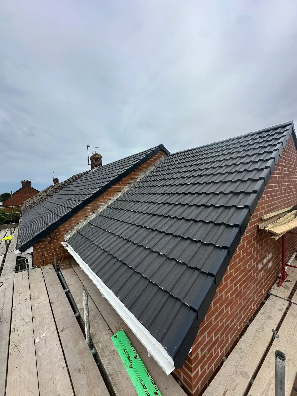 New pitched roof with dry verge system on grey interlocking tiles